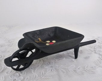 Tiny miniature wheelbarrow, black hand painted vintage cast iron wheel barrow ashtray, red flowers painted on the inside, the wheel spins!