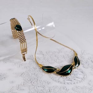 Trifari jewelry set of two pieces in gold with three green enamel leaves from the 1970s, includes a necklace, signed, and matching bracelet