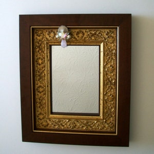 Mirror with ornate gold and walnut frame and vintage crystal and stone pin