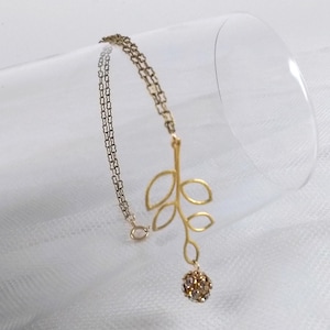 Delicate gold filled olive branch vintage bracelet with a double strand chain and a prong set rhinestone ball dangle, stamped 1/20 14k GF.