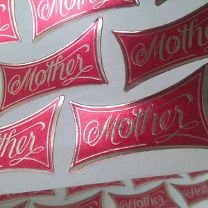 Fabulosas pegatinas vintage en papel de aluminio rojo y dorado que dicen "Madre" en una elegante letra. Perfectas para hacer tarjetas, envolver regalos, abuelas jóvenes y nuevas.