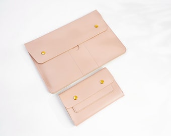 Può includere: Due pochette in pelle rosa con dettagli dorati. La pochette più grande ha una chiusura a lembo e la pochette più piccola ha un solo lembo. Entrambe le pochette hanno una texture sottile.