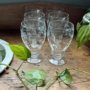 Puede incluir: Un letrero de madera rústica con el texto "Welcome to our home" en letras blancas. El letrero presenta un acabado envejecido y un diseño simple y acogedor, ideal para la decoración de la entrada.