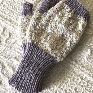 May include: A pair of fingerless gloves with a white and purple speckled pattern. The gloves have a solid purple cuff.