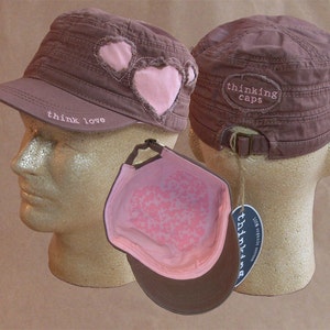 May include: Two brown canvas hats with pink hearts and the text "think love" and "thinking caps" embroidered on them.