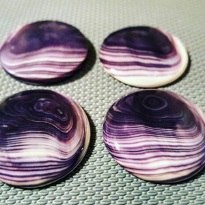 May include: Four round, smooth, polished stones with a swirling pattern of white and purple.