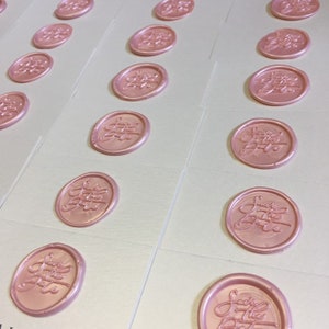 May include: Multiple white cards with pink wax seals that say "Save the Date" in cursive.