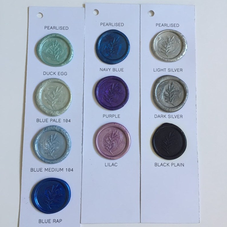 May include: A color chart of wax seal stamps with different colors and finishes. The colors include duck egg, blue pale, blue medium, blue rap, navy blue, purple, lilac, light silver, dark silver, and black plain.