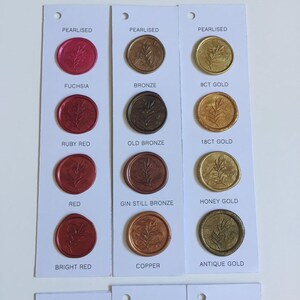 May include: A color chart of wax seal stamps with different colors and finishes. The colors include fuchsia, ruby red, red, bright red, bronze, old bronze, gin still bronze, copper, 9ct gold, 18ct gold, honey gold, and antique gold. The finishes include pearlised.