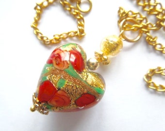 Murano glass pendant with a gold and red Murano glass heart and gold chain.