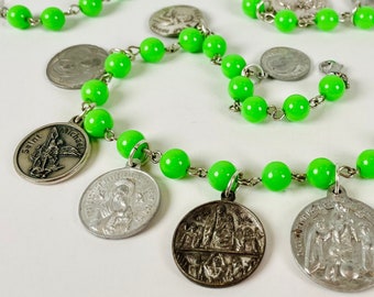 CIRCULAR LOGIC Round Religious Medallions Sit Below Vintage Chained Beads in a Bright Lime Green