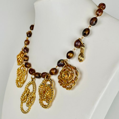 À LA ARAKI Knots shops and Rings of Rope Twist and Pose between Translucent Caramel Beads