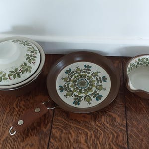 以下が含まれることがあります： 茶色と緑の花柄のヴィンテージキッチンウェア3点セット。セットには、蓋付き鍋、小鍋、サービングディッシュが含まれています。