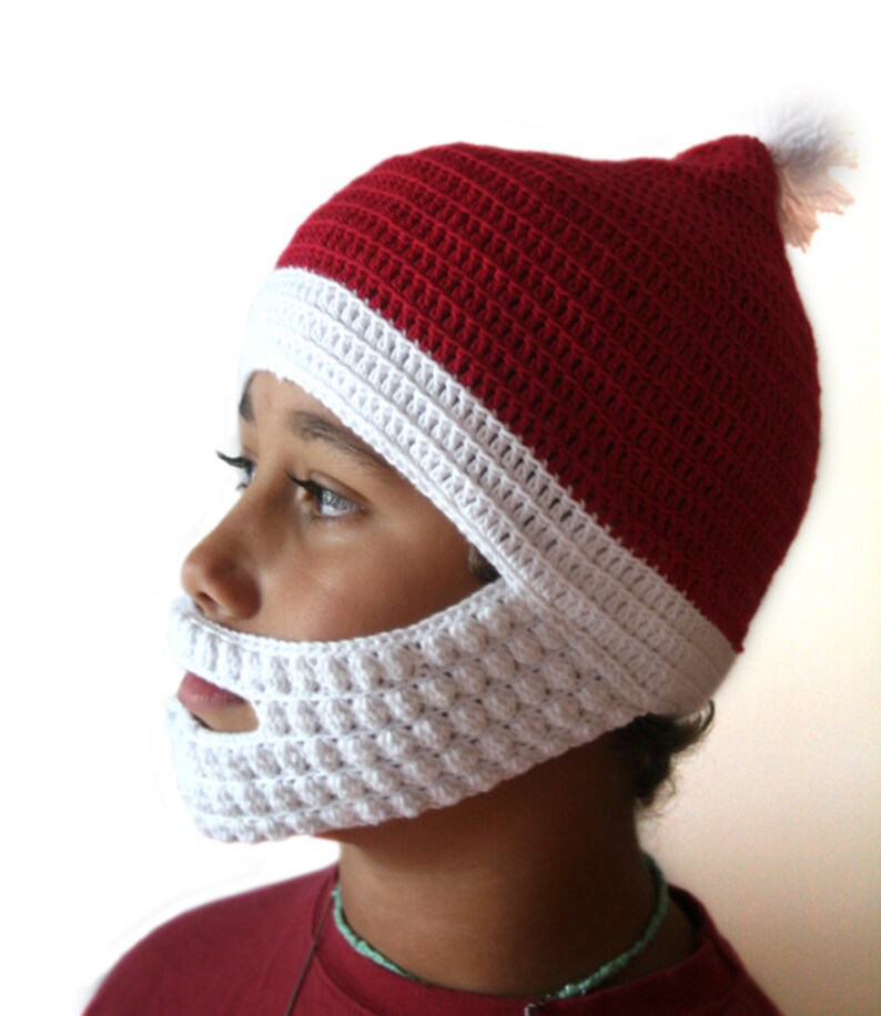 May include: A red and white crocheted Santa hat with a white crocheted beard. The hat has a white pom-pom on top.