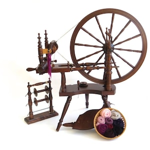 Kromski Polonaise spinning wheel with tensioned upright lazy kate, three bobbins and spinning fiber. Shop pacificwoolandfiber.com