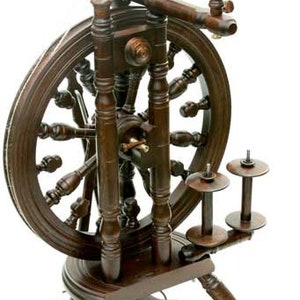 May include: A dark brown wooden spinning wheel with a large wheel and a smaller wheel on the side. The spinning wheel has a treadle and a footrest.