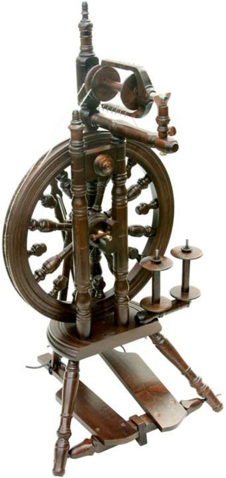 May include: A dark brown wooden spinning wheel with a large wheel and a smaller wheel on the side. The spinning wheel has a treadle and a footrest.