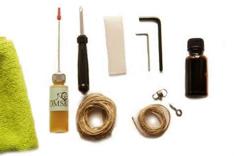 K&ouml;nnte beinhalten: Ein Satz Werkzeuge f&uuml;r Saiteninstrumente, bestehend aus einer &Ouml;lflasche, einem Schraubendreher, zwei Inbusschl&uuml;sseln, einem Filzst&uuml;ck, zwei Spulen mit Saiten, einem kleinen Metallhaken und einem Reinigungstuch.