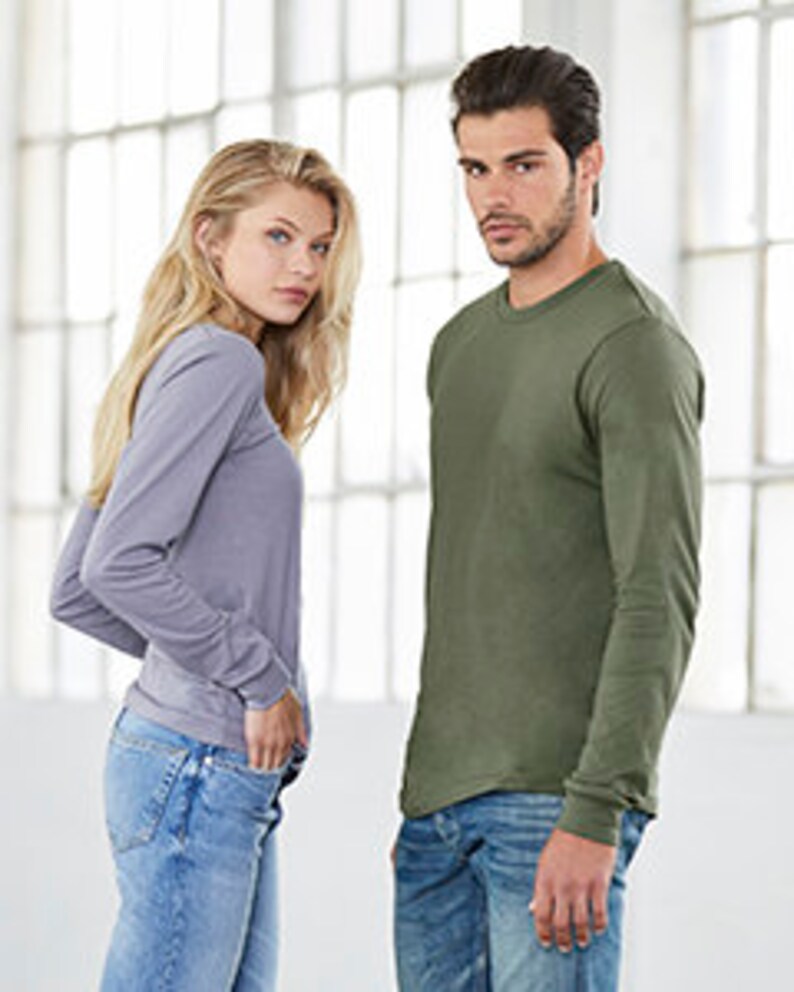 May include: A long-sleeved shirt in a light green colour with a relaxed fit. The shirt has a crew neck and a slightly curved hem.