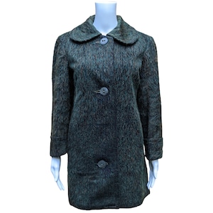 Può includere: Un cappotto con motivo verde, marrone e nero con colletto e quattro bottoni.