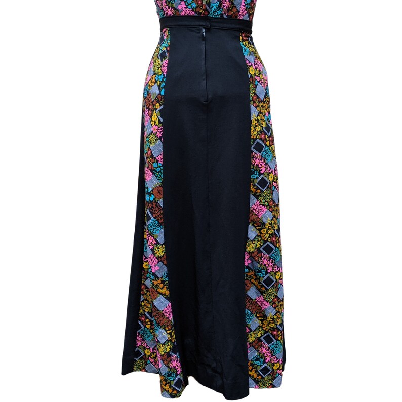 May include: A long black maxi dress with a colorful floral print on the sides. The dress has a back zipper closure.