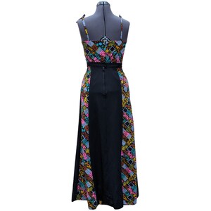 May include: A long black maxi dress with a colorful floral print on the sides. The dress has a fitted bodice and a flowing skirt.