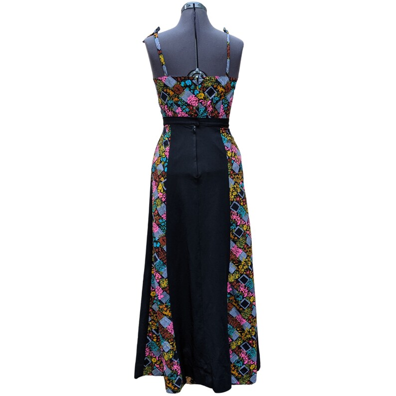 May include: A long black maxi dress with a colorful floral print on the sides. The dress has a fitted bodice and a flowing skirt.