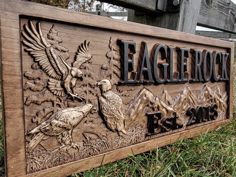 May include: A wooden sign with a carved eagle design and the text "Eagle Rock Est. 2018".