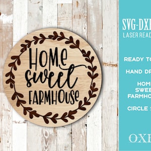 May include: A round wooden sign with the words "Home Sweet Farmhouse" in black script, surrounded by a brown leaf wreath. The sign is on a light wood background. Text on the right side reads "SVG-DXF-EPS Laser Ready Files".