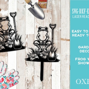 May include: Black and white silhouette of a frog holding a shovel. The frog is sitting on a small log and surrounded by flowers. The image is a digital cut file for crafting projects.
