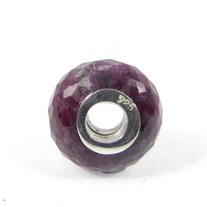 以下が含まれることがあります： ファセットカットされたルビーの宝石ビーズで、スターリングシルバーのコアが付いています。ビーズの側面には「925」の刻印があります。