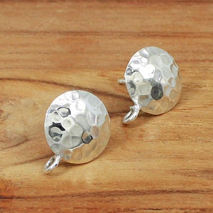 May include: Two silver hammered round earring findings with a loop on the bottom.