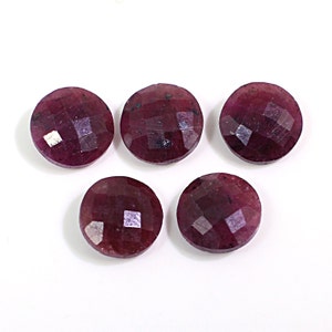 以下が含まれることがあります： 5つの丸いファセットカットのルビーの宝石。石は濃い赤色で、研磨された仕上げになっています。