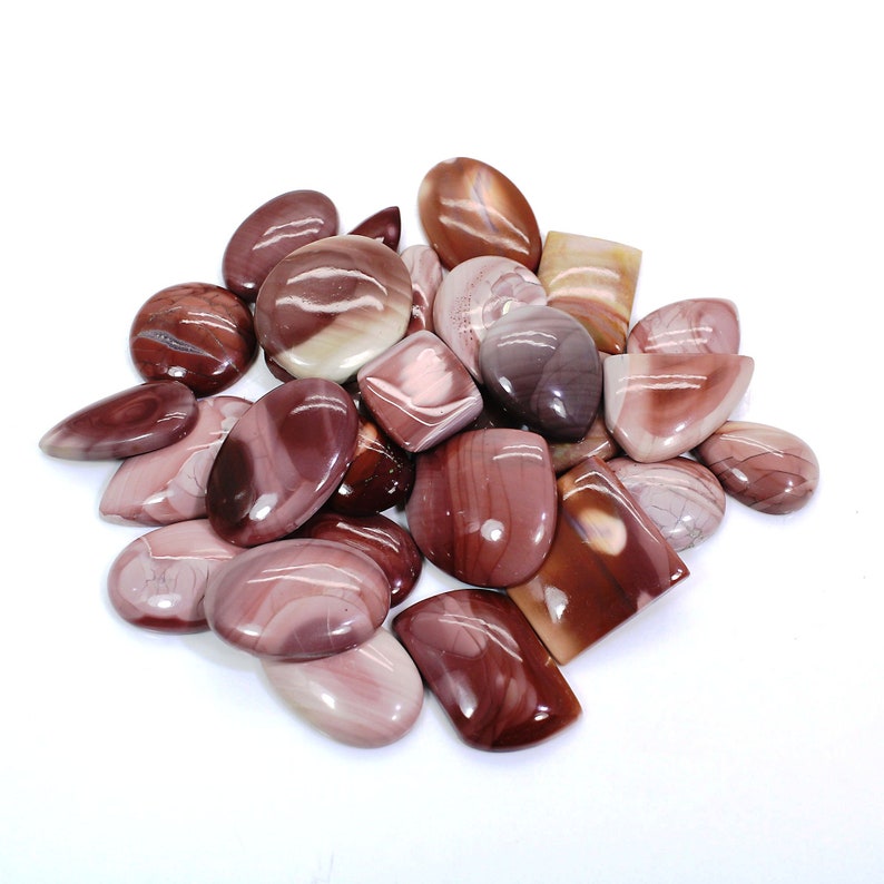 May include: A collection of 18 polished, natural, red and white banded agate cabochons. The cabochons are various shapes and sizes, with some being oval, round, and rectangular.