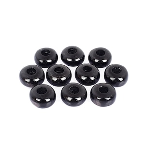Peut inclure: Dix perles en bois noires avec un trou au centre. Les perles sont rondes et ont une finition lisse et brillante.
