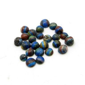 May include: A collection of round, multi-colored cabochons with blue, green, brown, and yellow patterns. The cabochons are approximately 1/2 inch in diameter.