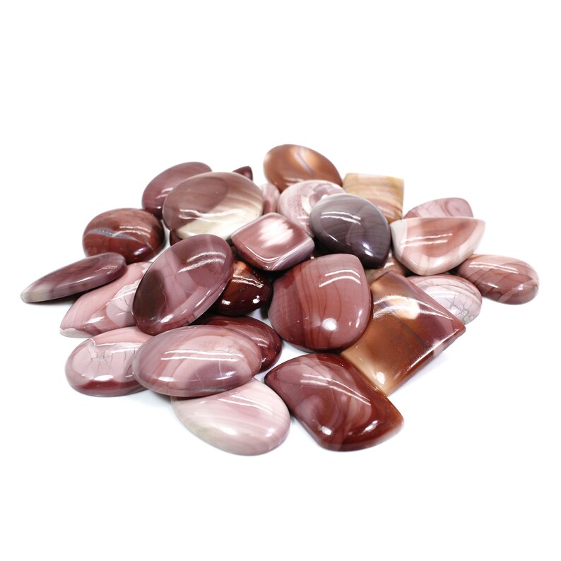 May include: A collection of polished, red and white, natural gemstone cabochons. The cabochons are various shapes and sizes, and have a smooth, polished finish.