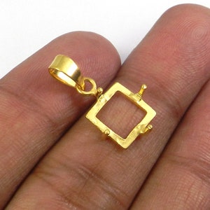 Puede incluir: Engaste de colgante de color dorado con marco cuadrado y cuatro garras. El colgante tiene un aro para sujetar una cadena.