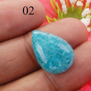 Puede incluir: Un cabuj&oacute;n de piedra preciosa en forma de l&aacute;grima, azul claro, verde y dorado. La piedra preciosa mide aproximadamente 2,5 cm de largo y 1,25 cm de ancho.