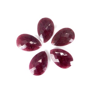 Op de afbeelding: Zes peervormige, gefacetteerde edelstenen in een diepe bordeauxrode kleur. De edelstenen zijn in een cirkelvormige opstelling op een witte achtergrond geplaatst.