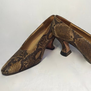 Peut inclure: Une paire de chaussures à talons en cuir de serpent brun avec une pointe pointue.