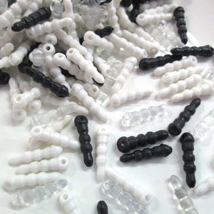 May include: A large pile of white and black plastic phone stylus tips. The tips are all the same shape, but some are clear, some are opaque white, and some are black.
