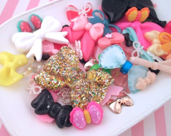 May include: Assortment of colorful bows and hair clips, including glitter, pink, blue, yellow, and black bows. Some bows have a sparkly finish.