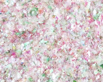 Könnte beinhalten: Nahaufnahme von schimmerndem Glitzer in den Farben Rosa, Grün und Weiß. Der Glitzer ist zufällig verteilt und erzeugt einen schimmernden Effekt.