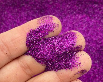以下が含まれることがあります： 手の中に、紫色のラメが山盛りになっている。ラメは細かく、キラキラと輝いている。