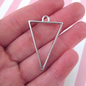 May include: Silver triangle pendant frame with a loop at the top for hanging.