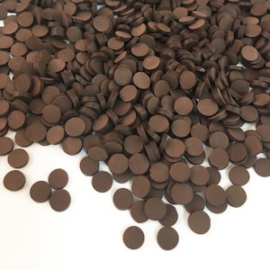 May include: A large pile of small, round, brown chocolate discs.