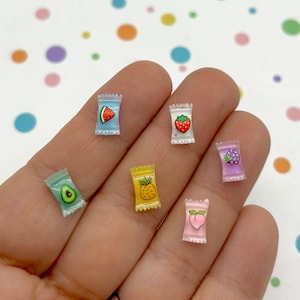 Può includere: Sei bustine di plastica in miniatura con diversi disegni di frutta. Le bustine sono trasparenti e mostrano i disegni di frutta all'interno. I frutti sono anguria, fragola, uva, ananas, pesca e avocado.