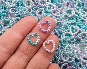 Könnte beinhalten: Sortiment an Perlen-Herz-Verzierungen in verschiedenen Blautönen, Rosa und Weiß. Die Herzen bestehen aus kleinen Perlen, die zu einer Herzform zusammengefügt sind.