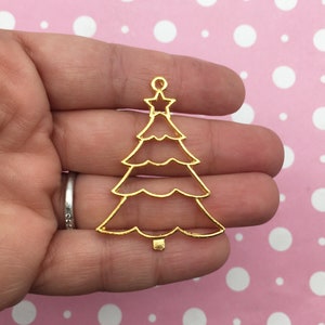 May include: Gold metal Christmas tree charm with a star at the top. The charm is hollow and has a layered design.